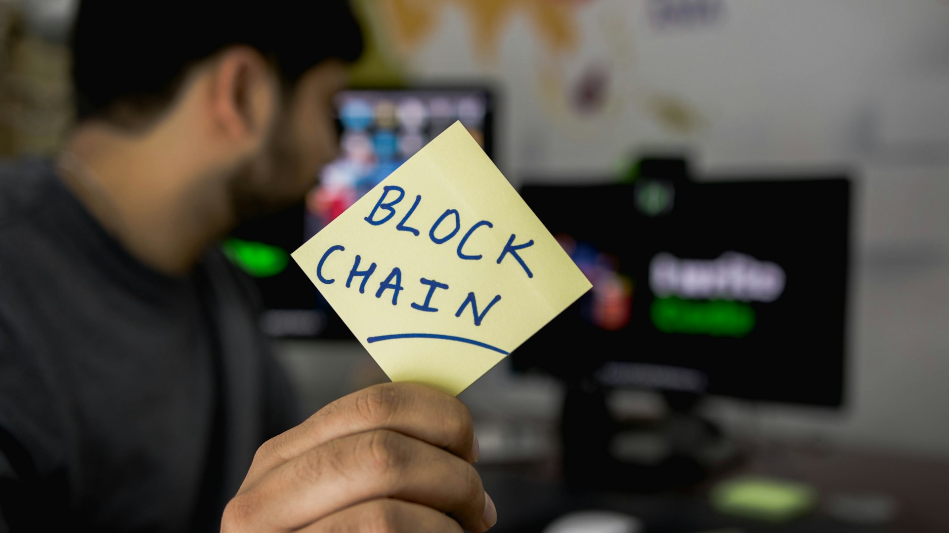 Hitesh Chaudhari holding a sticky note which has written "Block Chain"